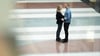 Couple stands face-to-face holding hands